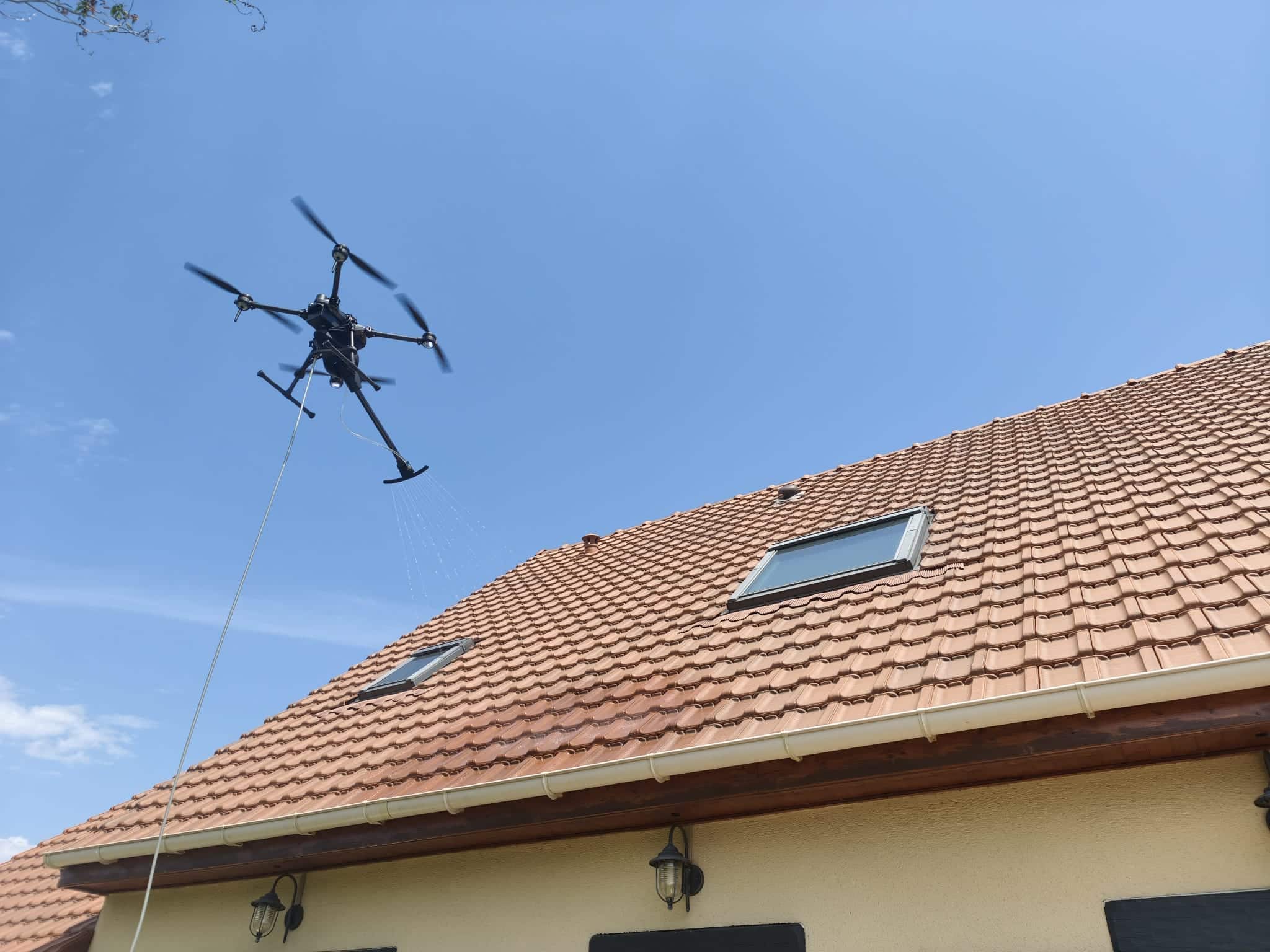 Drone effectue le nettoyage d'une toiture en tuiles en Normandie
