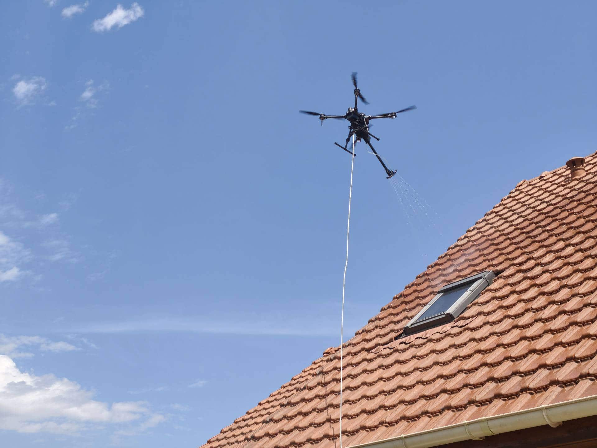 Drone Le Drone Normand pulvérisant un traitement anti-mousse sur une toiture en tuiles