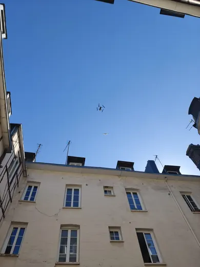 Drone survolant la façade d'un immeuble pour un nettoyage en hauteur