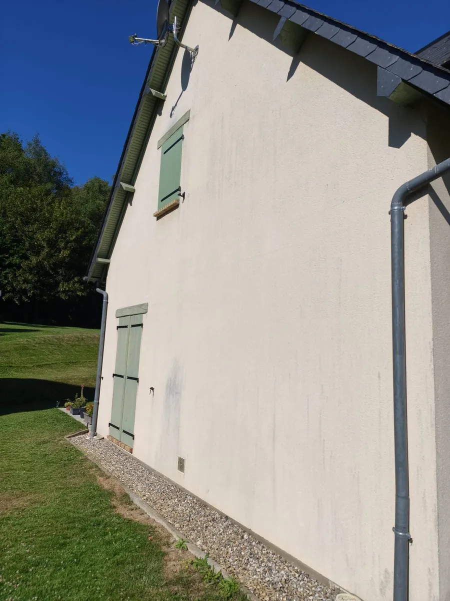 Pignon enduit taché de coulures noires avant nettoyage de façade en Normandie