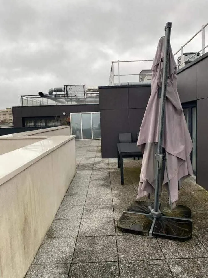 Terrasse en dalles noircie et mur encrassé avant nettoyage en Normandie